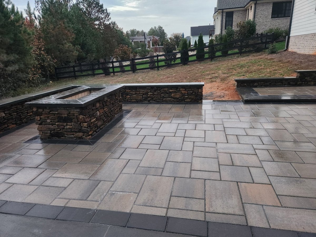 Patio with stone built-in seating and fireplace, paved with large flagstones in a residential backyard
